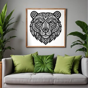 May include: A framed black and white bear head artwork featuring detailed tribal designs. The picture hangs above a grey sofa adorned with green cushions. Potted plants are positioned on either side of the sofa, enhancing the room's decor.