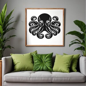 May include: A black octopus art print in a wooden frame hangs above a gray sofa with green pillows. The octopus design is a bold, stylized illustration. The room is decorated with large green plants, creating a natural and calming atmosphere.