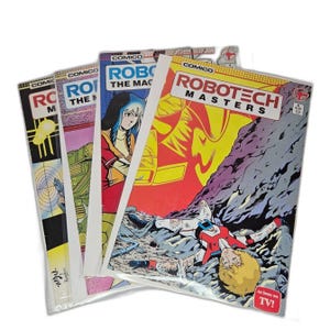 Puede incluir: Una pila de cómics vintage de Robotech. Las portadas presentan ilustraciones coloridas de personajes y escenas de la serie animada. Los cómics están en fundas de plástico.
