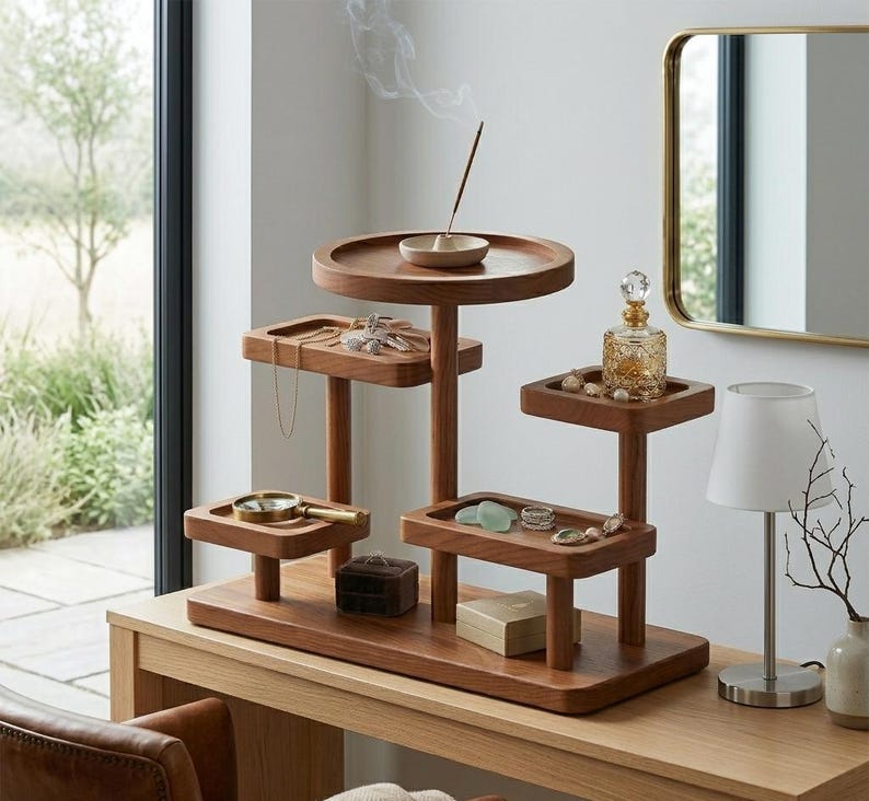 May include: A multi-tiered wooden jewelry and trinket organizer with a round base and several small trays. The organizer has a natural wood finish and holds jewelry, small boxes, and a decorative perfume bottle. An incense stick is lit on the top tier.