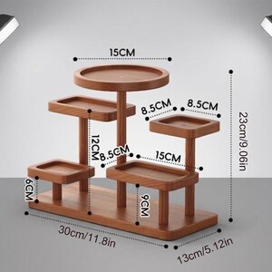 May include: A multi-tiered wooden plant stand with various levels for displaying plants or decor. The stand is 11.8 inches long, 5.12 inches wide, and 9.06 inches tall. Each tier is a different size and shape.