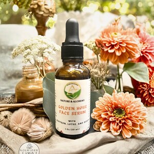 May include: A brown glass bottle of Golden Hour Face Serum with a black dropper, set against a backdrop of orange flowers and greenery. The label reads "Nature & Alchemy" and lists ingredients. The bottle is 1 fl oz (30 ml).