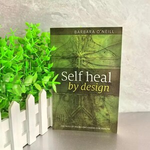 Może przedstawiać: Książka zatytułowana "Self heal by design" autorstwa Barbary O'Neill. Okładka przedstawia zielono-brązowy wz&oacute;r z ilustracjami anatomicznymi. Podtytuł książki brzmi "The Role of Micro-organisms for Health".