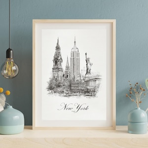 May include: A framed black and white print of the New York City skyline, including the Empire State Building and the Statue of Liberty. The word "New York" is written in cursive at the bottom of the print. The frame is light-colored wood.