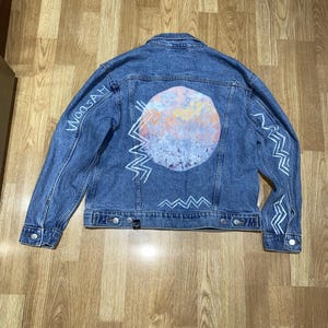 Puede incluir: Un letrero de madera rústica con el texto "Welcome to our home" en letras blancas. El letrero presenta un acabado envejecido y un diseño sencillo y acogedor, ideal para la decoración de la puerta principal.