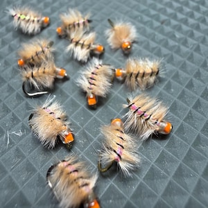 May include: A set of three ceramic mugs with a speckled, matte finish. The mugs are in shades of cream, light gray, and dark gray. Each mug has a simple, minimalist design, perfect for coffee or tea.