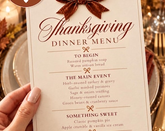 May include: A 5x7 inch Thanksgiving dinner menu card featuring a brown velvet bow at the top. The text lists courses including roasted pumpkin soup, herb-roasted turkey, and classic pumpkin pie, with the phrase A table full of love & gratitude.