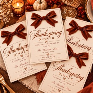 May include: Four rectangular cream-colored Thanksgiving dinner invitation cards, each featuring a dark brown velvet bow attached at the top. The text reads: You're invited to a Thanksgiving Dinner, Thursday, November 26, 4:00 PM, The Hamilton Home, 25 Maple Lane, Please RSVP to Amelia 021 234 5678.