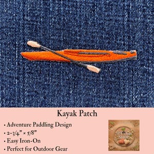 May include: An embroidered iron-on patch featuring a bright orange kayak with a dark grey cockpit and a double-bladed paddle resting across it. The patch measures 2-3/4 inches by 5/8 inches and is displayed against a dark blue denim fabric background.