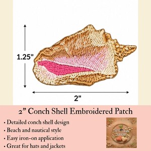 May include: An embroidered conch shell patch featuring shades of tan, cream, and a vibrant pink center. The patch measures 2 inches in width and 1.25 inches in height as indicated by the black dimension arrows and text on the white background.