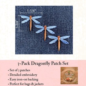 May include: A set of three embroidered dragonfly patches featuring light blue wings and a tan body. The patches are displayed on a dark blue denim fabric. Measurement lines indicate a width of 1-1/4 inches and a height of 1-3/4 inches.