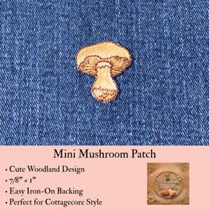 May include: An embroidered mushroom patch featuring tan and brown thread colors, measuring 7/8 inches by 1 inch. The patch is displayed against a blue denim fabric background. The text Mini Mushroom Patch is visible below the embroidered design.