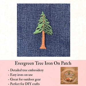 May include: An evergreen tree iron-on patch. The patch features detailed green tree embroidery with a brown trunk. The patch is shown on a blue denim background. The text "Evergreen Tree Iron On Patch" is below the patch.