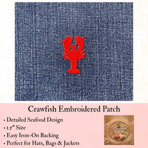 May include: A bright red embroidered crawfish patch featuring a detailed crustacean design. The patch is centered on a dark blue denim fabric background. The text on the product listing indicates a size of 1.5 inches for this iron-on accessory.
