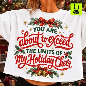 May include: A white crewneck sweatshirt featuring a festive graphic with red and green text that reads: YOU ARE about to exceed THE LIMITS OF MY Holiday Cheer. The design includes holly leaves, red berries, a red bow, and gold bells.