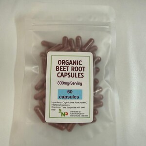 May include: A clear plastic bag filled with brown capsules. A white label displays "ORGANIC BEET ROOT CAPSULES" with "800mg/Serving" and "60 capsules". The label also lists ingredients and directions.