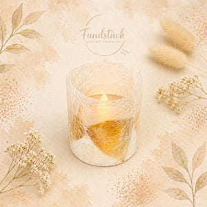 Op de afbeelding: Een decoratieve kaars met een warm, flikkerend licht, omhuld door een witte en gouden textuur. De afbeelding toont de tekst "Fundstück" en is omgeven door gedroogde bloemen en bladeren, wat een zachte, neutrale esthetiek creëert.