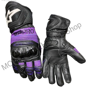 Puede incluir: Par de guantes de moto negros y morados. Los guantes tienen nudillos reforzados y un logotipo blanco en el pu&ntilde;o. El texto "SPRO" es visible en la zona de la mu&ntilde;eca. Los guantes son de cuero y tienen un dise&ntilde;o perforado.