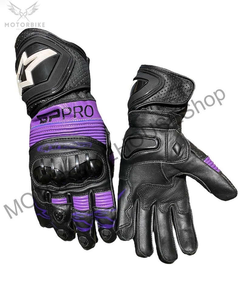 Puede incluir: Par de guantes de moto negros y morados. Los guantes tienen nudillos reforzados y un logotipo blanco en el pu&ntilde;o. El texto "SPRO" es visible en la zona de la mu&ntilde;eca. Los guantes son de cuero y tienen un dise&ntilde;o perforado.
