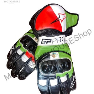 Könnte beinhalten: Paar schwarze, weiße, rote und grüne Motorradhandschuhe. Die Handschuhe haben ein Sternlogo und den Text "GP PRO". Die Handschuhe haben schwarze Knöchelschützer und sind aus Leder.