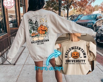 Może przedstawiać: Beżowa bluza z długim rękawem z grafiką na plecach przedstawiającą dynię, budynek i napis HALLOWEENTOWN EST. 1998. Grafika z przodu przedstawia dynię oraz napis HALLOWEENTOWN UNIVERSITY EST. 1998 WHERE BEING NORMAL IS VASTLY OVERRATED.