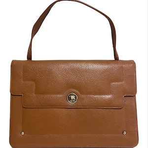 May include: A brown leather handbag with a single handle. The bag has a rectangular shape with a flap closure and a silver-colored clasp. The leather has a textured appearance, and the bag has a simple, classic design.
