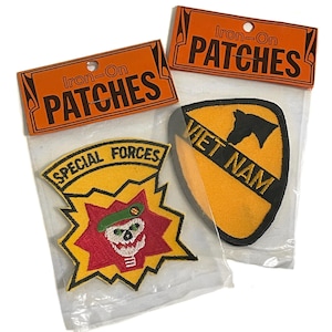 May include: Two iron-on patches in clear plastic packaging. One patch features a skull wearing a green beret, surrounded by a red and yellow burst design, with the words "SPECIAL FORCES". The other patch is yellow with a black horse head and the words "VIET NAM".