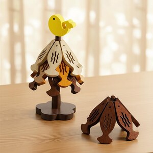 Op de afbeelding: Houten decoratieve ornamenten in de vorm van een vogel en vissen. De vogel is geel en zit bovenop een structuur van gelaagde vissen in bruin- en beigetinten. Er is ook een aparte set visvormige ornamenten aanwezig.