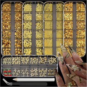 May include: A collection of gold nail art decorations in various shapes and sizes, including beads, stars, and bows, displayed in clear plastic containers. A pair of tweezers and a pencil are also included. The image also shows a hand with long, decorated nails.