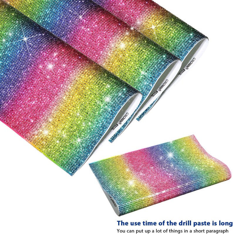 May include: A set of rainbow-colored rhinestone sheets featuring a dense, sparkling gradient of blue, green, yellow, and pink crystals. The sheets have a flexible backing and are labeled with the text CROWN #513L on the white edge.