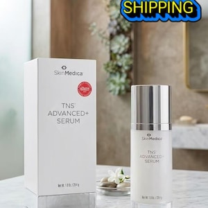 May include: A white SkinMedica TNS ADVANCED+ SERUM box and a matching cylindrical pump bottle. The packaging features black text, a red circular award seal, and states a net weight of 1.0 oz. / 28.4 g. The bottle has a silver cap and base.
