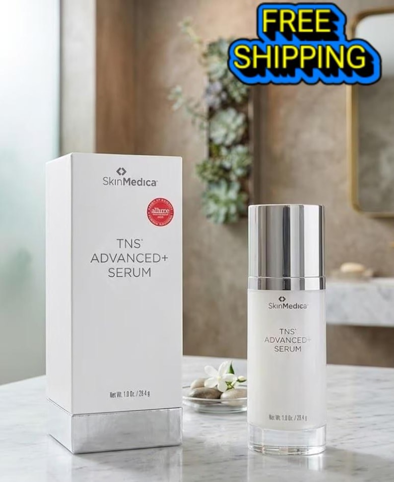 May include: A white SkinMedica TNS ADVANCED+ SERUM box and a matching cylindrical pump bottle. The packaging features black text, a red circular award seal, and states a net weight of 1.0 oz. / 28.4 g. The bottle has a silver cap and base.