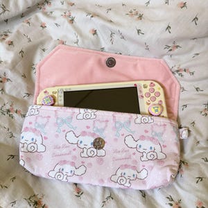 以下が含まれることがあります： 黒い持ち手と「But First, Coffee」の太字の黒い文字が入った白いセラミックマグ。マグカップは木製の表面に置かれています。マグカップの高さは約10cmです。