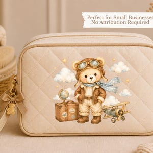 May include: A beige quilted rectangular cosmetic bag with a zipper closure and a small bear-shaped charm. The front features a printed illustration of a bear dressed as an aviator with a globe, a suitcase, and a small airplane among clouds.