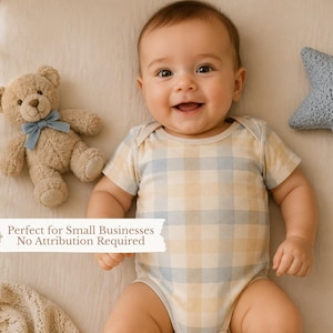 May include: A baby wearing a short-sleeved bodysuit with a light blue and yellow plaid pattern, lying next to a tan plush teddy bear with a blue ribbon and a blue crocheted star-shaped pillow. The image includes text reading Perfect for Small Businesses No Attribution Required.