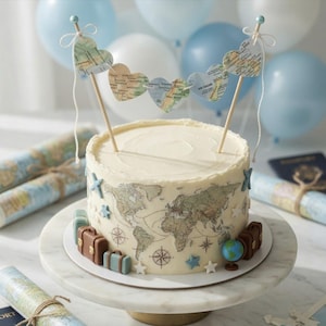 Könnte beinhalten: Ein runder Kuchen, verziert mit einem Weltkarten-Design, Dekorationen zum Thema Reisen und einem herzförmigen Banner. Der Kuchen zeigt Miniaturkoffer, einen Globus und Sternakzente. Der Kuchen steht auf einem weißen Kuchenständer, mit blauen und weißen Luftballons im Hintergrund.
