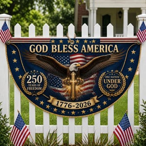 以下が含まれることがあります： 「GOD BLESS AMERICA」の文字とワシのグラフィックが描かれた愛国的なバナー。バナーにはアメリカ国旗、十字架、「250 YEARS OF FREEDOM」と「ONE NATION UNDER GOD」の文字が含まれています。バナーは、アメリカ国旗が飾られた白い柵に表示されています。