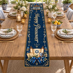 May include: A long, rectangular navy blue table runner featuring the gold text Happy Passover. The design includes a gold menorah at the top, a central scroll with a Star of David, matzah, a kiddush cup, and blue ribbon accents with gold leaves.