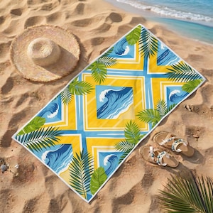 May include: A beach towel with a yellow, blue, and white wave and palm leaf design. A straw hat and sandals are on the sand. The ocean is visible in the background. The towel is likely 180 cm long.