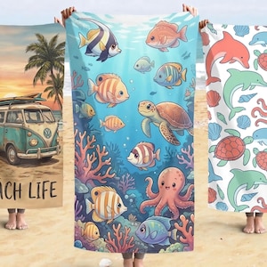 Könnte beinhalten: Drei Strandtücher mit farbenfrohen Designs werden gezeigt. Eines zeigt einen tealfarbenen Van mit Surfbrett, Palmen und dem Text "BEACH LIFE". Ein anderes zeigt eine Unterwasserszene mit Fischen und einer Schildkröte. Das dritte hat Delfine, Schildkröten und Muscheln.