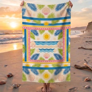 Peut inclure: Serviette de plage avec un motif tropical représentant des coquillages, des feuilles de palmier et des soleils sur un fond crème. La serviette a des bordures bleues, roses et jaunes. La serviette est tenue sur une plage avec le soleil couchant en arrière-plan.