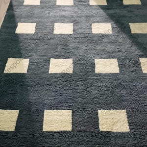 Tapete geométrico cinza escuro, feito à mão, com padrão quadrado, em lã, design moderno e minimalista em forma de grade, macio e artesanal.