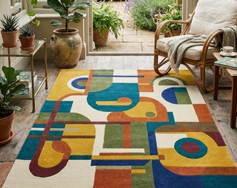 Puede incluir: Una alfombra rectangular con un diseño geométrico abstracto. La alfombra presenta un fondo crema con formas en azul, amarillo, naranja, verde y burdeos. Está colocada sobre un suelo de ladrillo en un invernadero.