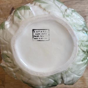 May include: A white ceramic mug with a black handle and the text "But First, Coffee" in a handwritten style. The mug is on a white surface. The mug is approximately 4 inches tall.