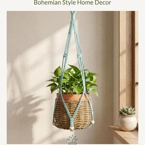 May include: A handmade macrame plant hanger with a woven basket holding a green leafy plant. The hanger is made of light blue cotton rope and features natural wood beads. The text reads "Handmade Macrame Plant Hanger Bohemian Style Home Decor."