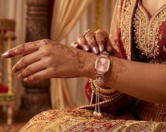 Pulsera de reloj vintage de oro rosa con perlas y piedras preciosas, accesorio de moda con temática floral.