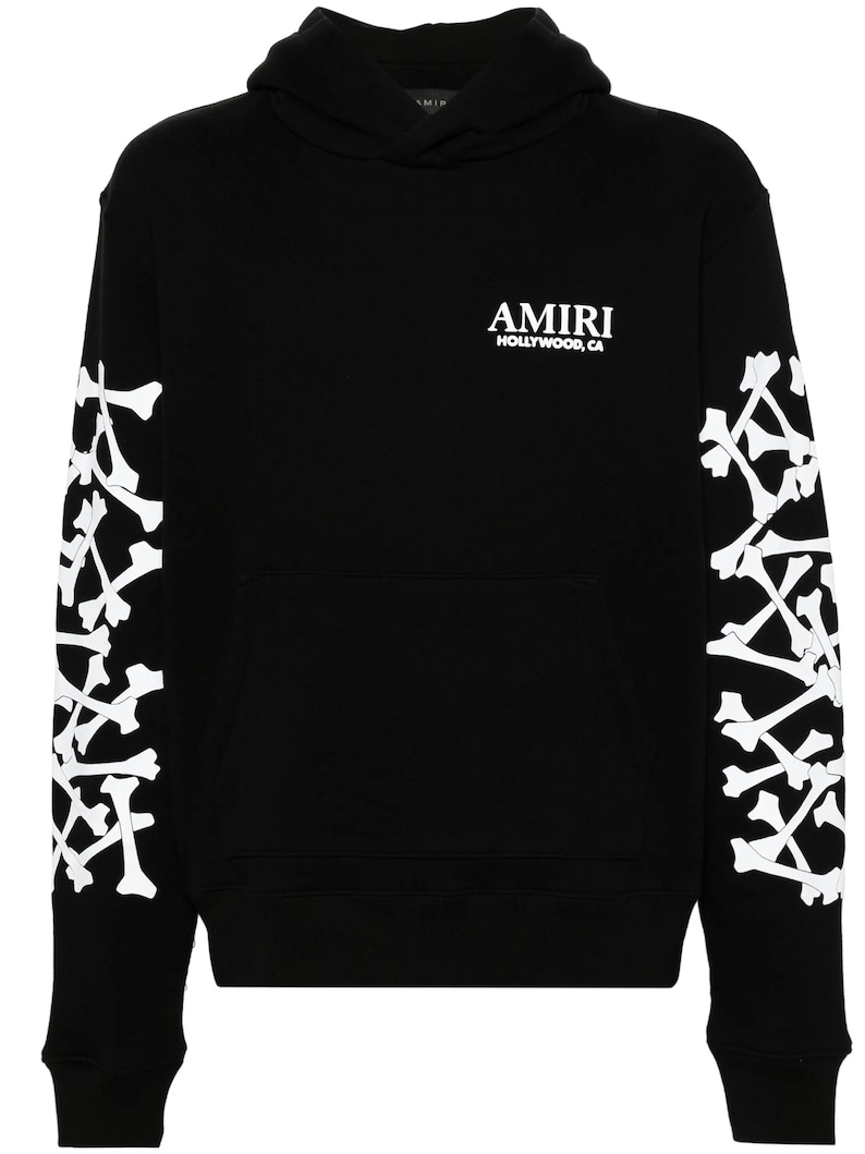 May include: Black hoodie with white bone designs on the sleeves. The hoodie has a front pocket and the word "AMIRI" in white, with "HOLLYWOOD, CA" underneath. A casual, streetwear-style garment.