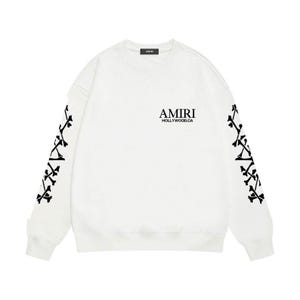 May include: White sweatshirt with black graphic details. The sleeves feature a black bone design. The chest displays the text "AMIRI HOLLYWOOD.CA" in black. A small black label is at the neckline.