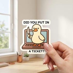 Puede incluir: Una pegatina con un pato de dibujos animados sosteniendo un cuchillo frente a una computadora portátil. El texto de la pegatina dice "DID YOU PUT IN A TICKET?" El pato es amarillo con patas naranjas y un pico marrón.