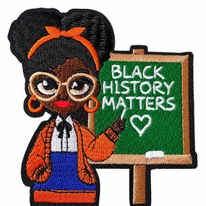 May include: An embroidered patch featuring a character with dark skin, glasses, and an orange headband, wearing an orange cardigan over a white shirt and blue skirt. The character stands before a green chalkboard with the text BLACK HISTORY MATTERS.